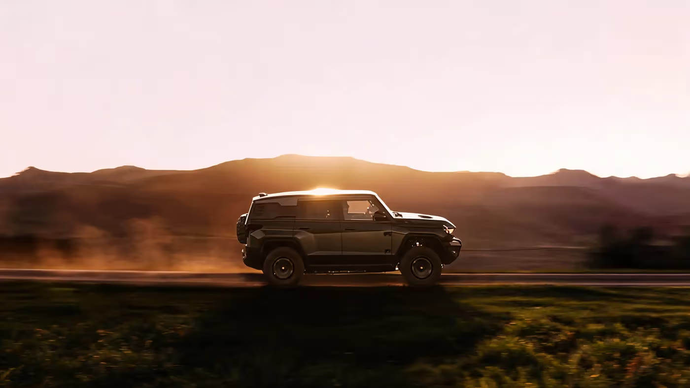 An MHERO 1 driving into the sunset on an open mountain road